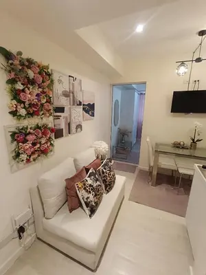 a living room with a white couch and flowers on the wall at Azure Urban Resort Staycation in Manila