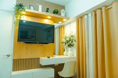 a bathroom with a television on a wall at Consider It Yours - Stay Cozy with City Views in Manila