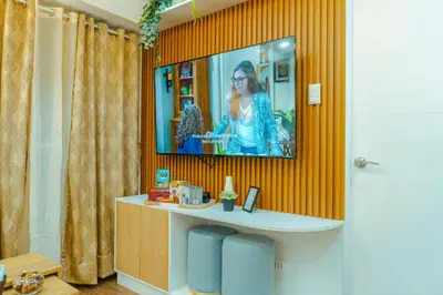 a tv on a wall in a room at Consider It Yours - Stay Cozy with City Views in Manila