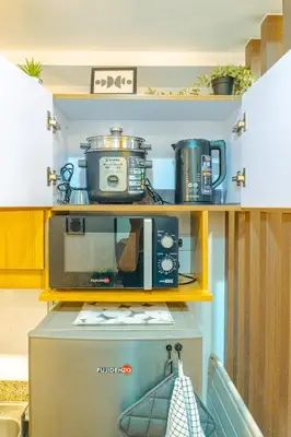 a kitchen with a microwave and a coffee maker at Consider It Yours - Stay Cozy with City Views in Manila