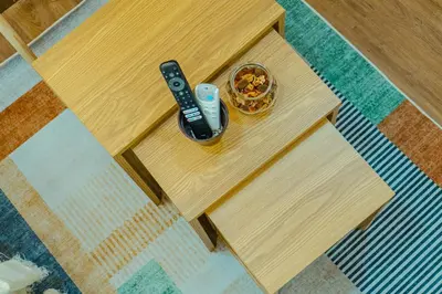 a table with two remote controls and a bowl of food at Consider It Yours - Stay Cozy with City Views in Manila