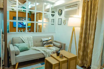 a living room with a couch and a table at Consider It Yours - Stay Cozy with City Views in Manila