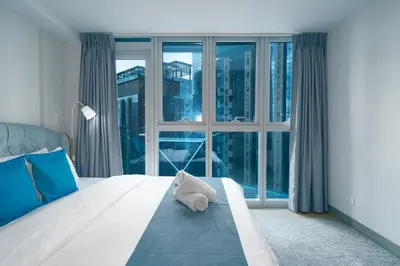a bedroom with a bed with a large window at Uptown Parksuites Upscale Spacious Cor Unit Balcony and Views in Manila