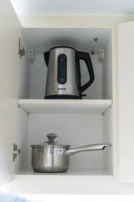 a tea kettle and a pot sitting on shelves at Uptown Parksuites Upscale Spacious Cor Unit Balcony and Views in Manila