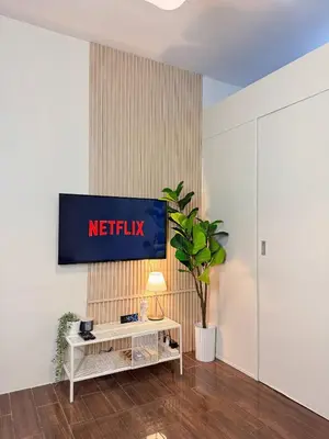 a living room with a television on a wall at Entire Place in Central Makati in Manila