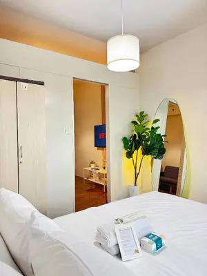 a bedroom with a white bed and a mirror at Entire Place in Central Makati in Manila
