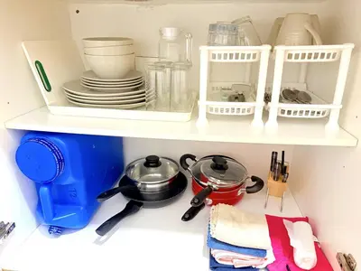 a shelf with dishes and utensils in a kitchen at Instaworthy Space near BGC NAIA at Grace Res in Manila
