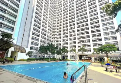 a swimming pool in front of a large building at Instaworthy Space near BGC NAIA at Grace Res in Manila
