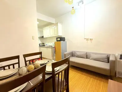 a kitchen and living room with a table and a couch at Instaworthy Space near BGC NAIA at Grace Res in Manila