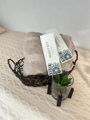 a basket of towels and books on a bed at Leaf Residences Muntinlupa - The Mint Pearl Stay 2 bedroom in Manila