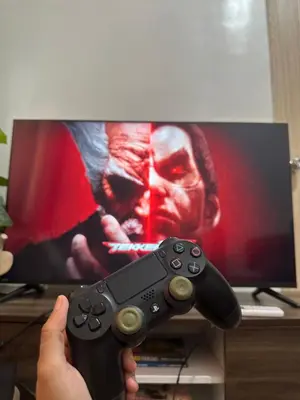 a person holding a video game controller in front of a tv at Leaf Residences Muntinlupa - The Mint Pearl Stay 2 bedroom in Manila