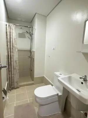 a white bathroom with a toilet and a sink at Leaf Residences Muntinlupa - The Mint Pearl Stay 2 bedroom in Manila