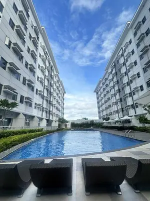 a large swimming pool in front of two buildings at Leaf Residences Muntinlupa - The Mint Pearl Stay 2 bedroom in Manila