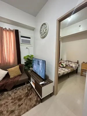 a living room with a tv and a mirror at Leaf Residences Muntinlupa - The Mint Pearl Stay 2 bedroom in Manila