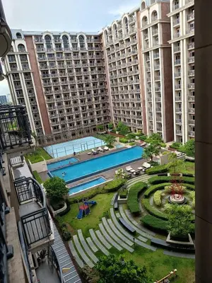 a large apartment building with a pool and a garden at Condo MOA with pool access WS811 in Manila