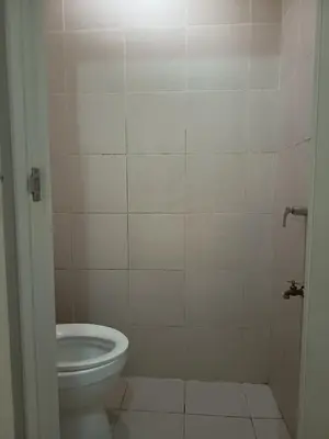 a bathroom with a toilet and a tiled wall at Condo MOA with pool access WS811 in Manila