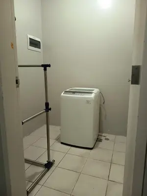 a small white refrigerator sitting in a room at Condo MOA with pool access WS811 in Manila