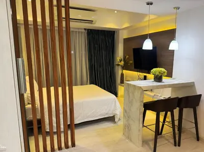 a hotel room with a bed and a desk and a kitchen at Modern Condo with Premium Beach View at Azure Urban Resort Residences - Vesta Property in Manila