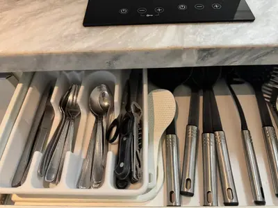 a drawer filled with utensils under a counter at Modern Condo with Premium Beach View at Azure Urban Resort Residences - Vesta Property in Manila