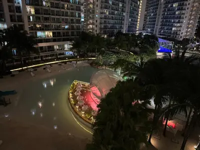 a large swimming pool in a city at night at Modern Condo with Premium Beach View at Azure Urban Resort Residences - Vesta Property in Manila