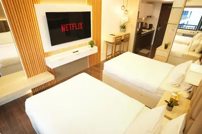 a hotel room with a tv and two beds at Hotel Like Staycation 3 Makati with Amazing View in Manila