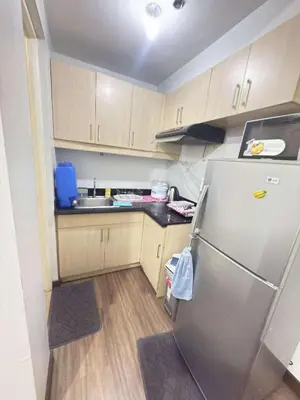 a small kitchen with a refrigerator and a sink at La verti 1BR Affordable staycation for family groups in Manila