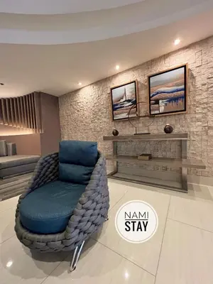 a living room with a blue chair in a room at Nami Stay at Shore Residences 1 in Manila