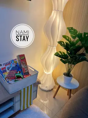 a bedroom with a nammi stay sign next to a plant at Nami Stay at Shore Residences 1 in Manila