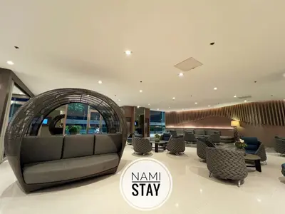 a lobby with a couch and chairs and a sign that says nani stay at Nami Stay at Shore Residences 1 in Manila