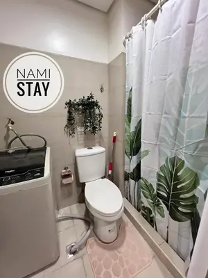 a bathroom with a toilet and a shower curtain at Nami Stay at Shore Residences 1 in Manila