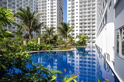 a swimming pool in the middle of a building with tall buildings at Nami Stay at Shore Residences 1 in Manila