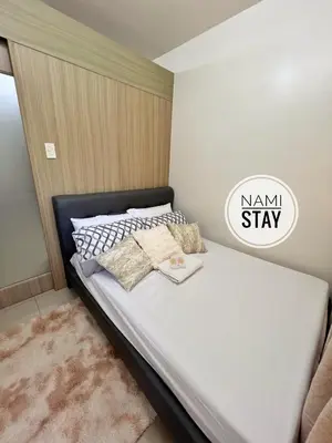 a bedroom with a bed with a smallstay sign on it at Nami Stay at Shore Residences 1 in Manila