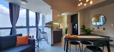 a kitchen and living room with a table and chairs at BGC Family Suite Steps Away from Mall with FREE Parking with Washer Dryer in Manila