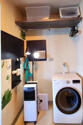 a laundry room with a washing machine and a lamp at BGC Family Suite Steps Away from Mall with FREE Parking with Washer Dryer in Manila