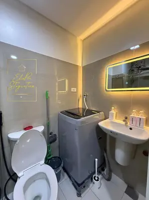 a bathroom with a white toilet and a sink at ElcaPri Staycation Unit 2 - Shore 2 in Manila