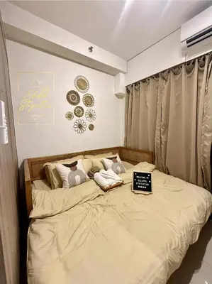 a bedroom with a bed with a laptop on it at ElcaPri Staycation Unit 2 - Shore 2 in Manila