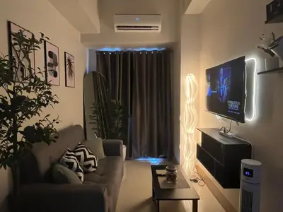a living room with a couch and a flat screen tv at Cozy Minimalist Condo unit in Manila