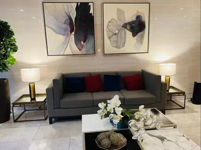 a living room with a couch and paintings on the wall at Staycation 15 minutes from NAIA with Massage Chair in Manila