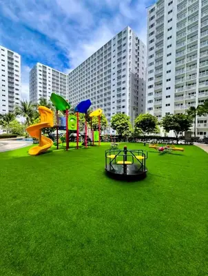 a playground in a park with a large building at SLY Staycation at Shore Residences Mall of Asia in Manila