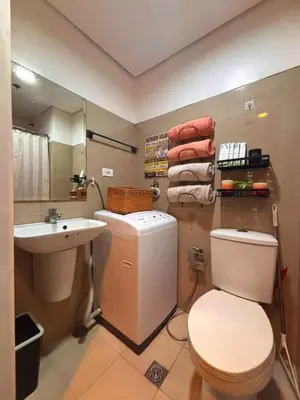 a bathroom with a white toilet and a sink at SLY Staycation at Shore Residences Mall of Asia in Manila