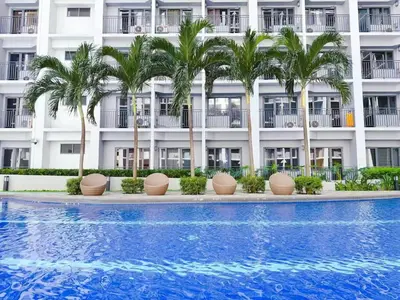 a hotel with palm trees in front of a swimming pool at shore 2 tower 3 near moa in Manila