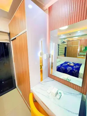 a bathroom with a mirror and a bed in it at shore 2 tower 3 near moa in Manila