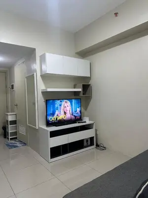 a living room with a flat screen tv on a wall at Bright & Cozy 1 BR in Jazz Residences Tower B in Manila