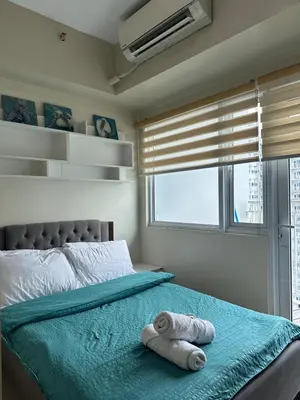 a bedroom with a bed with towels on it at Bright & Cozy 1 BR in Jazz Residences Tower B in Manila