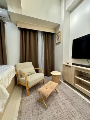 a hotel room with a bed and a chair and a television at Jays BnB in Manila
