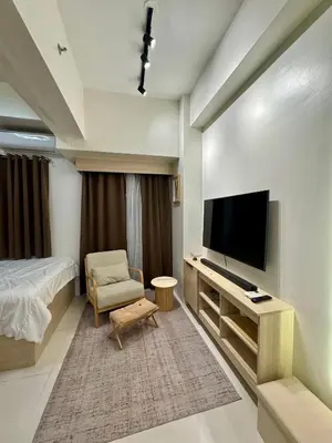 a bedroom with a bed and a tv and a chair at Jays BnB in Manila