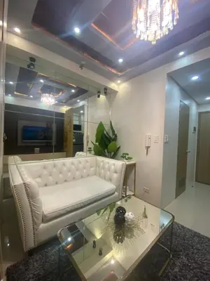a living room with a white couch and a glass table at MGS Suite Shore 2 Residences in Manila