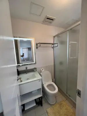 a bathroom with a toilet and a sink and a shower at Angel's Place Torre De Manila, Cozy 1BR Condo, Sunset View Near all Attractions in Manila