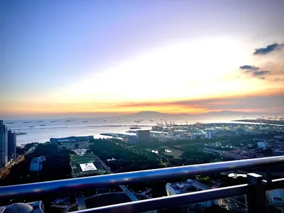 a view of the ocean and a city at sunset at Angel's Place Torre De Manila, Cozy 1BR Condo, Sunset View Near all Attractions in Manila