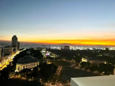 a view of a city at night with a sunset at Angel's Place Torre De Manila, Cozy 1BR Condo, Sunset View Near all Attractions in Manila